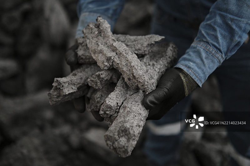 一个人手握焦煤块图片素材