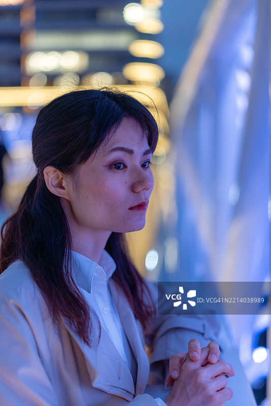 下班后，女商人站在桥上俯瞰风景的特写镜头图片素材