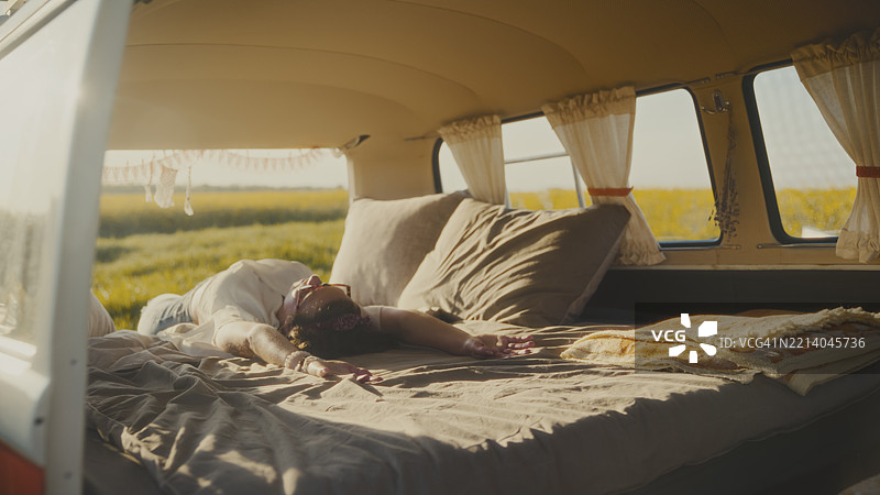 女人在田野中的房车床上放松图片素材