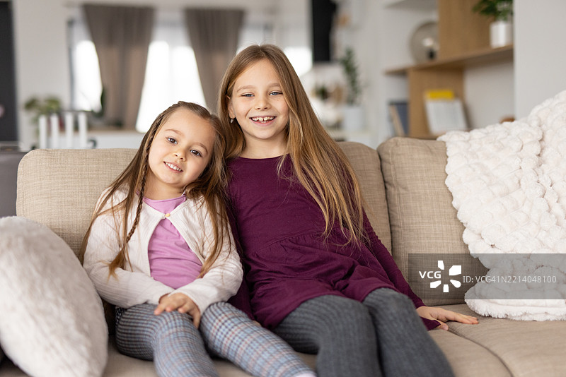 两个快乐的女孩摆姿势拍摄有趣的姐妹肖像图片素材