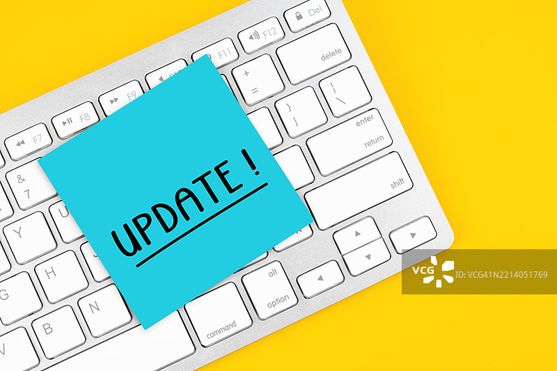 键盘上的粘性便签，背景为黄色，上面写着“更新”图片素材