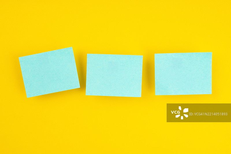蓝色空白便签纸在黄色背景上。图片素材