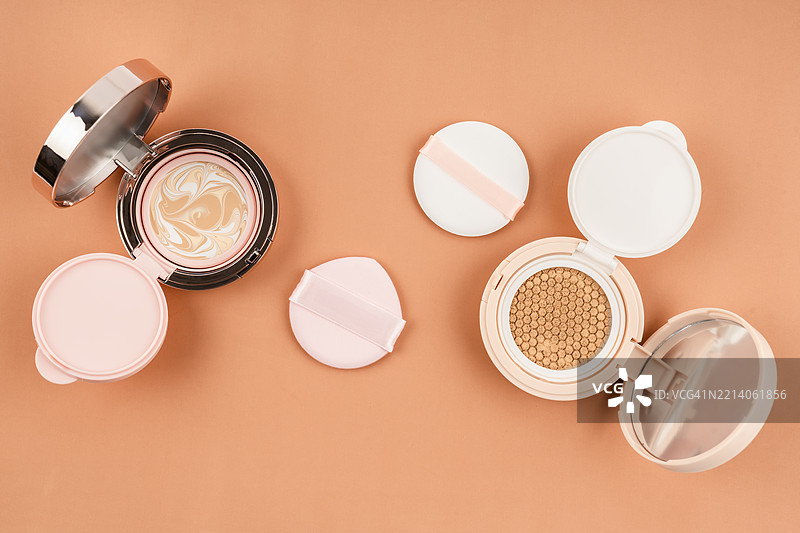 棕色背景上的化妆产品气垫粉底与海绵化妆工具图片素材