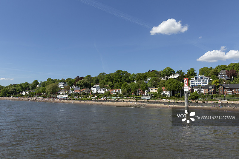 五月的夏季天气，人们在德国汉堡的埃尔贝海滩奥维尔根享受日光浴。图片素材