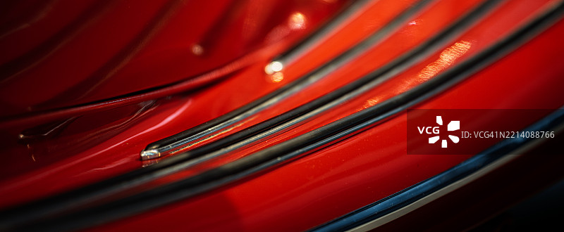 柔和光线照亮的鲜艳红色表面的曲线细节图片素材