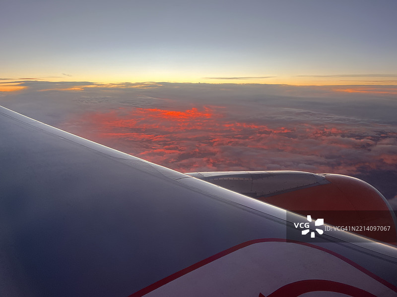飞机机翼在日落时分飞越法国的天空与风景的裁剪图像图片素材