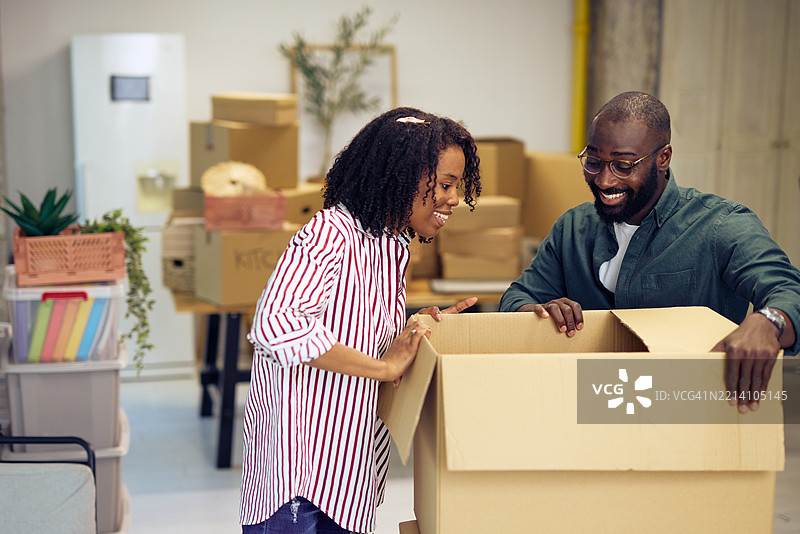 年轻情侣在新办公室拆纸箱图片素材