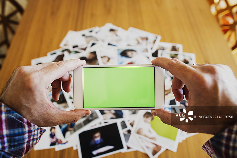 用智能手机拍摄桌上打印照片的回忆图片素材