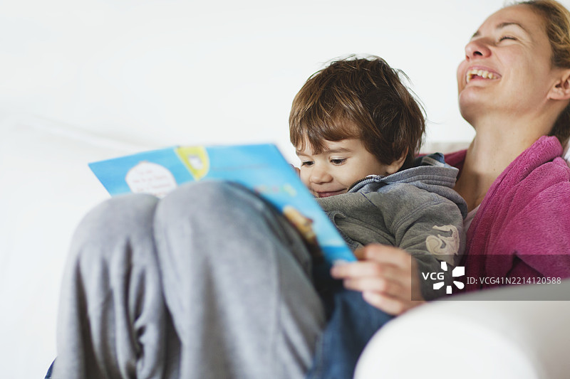 母亲和儿子在室内共享快乐的阅读时光图片素材