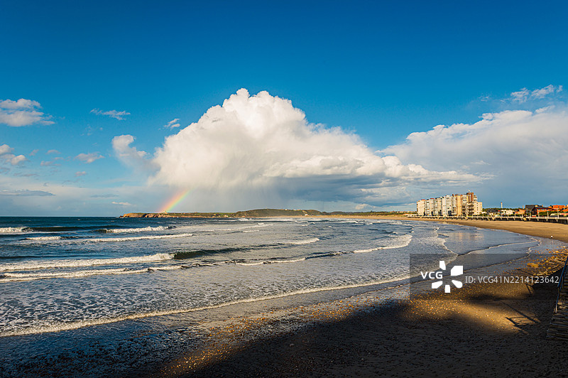彩虹触及西班牙阿斯图里亚斯的萨利纳斯海滩海岸图片素材