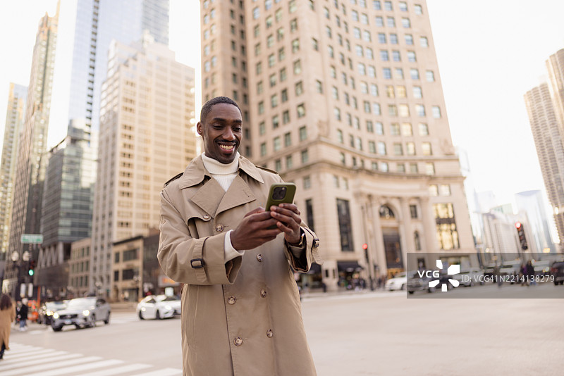 在芝加哥市中心微笑的商人使用智能手机图片素材