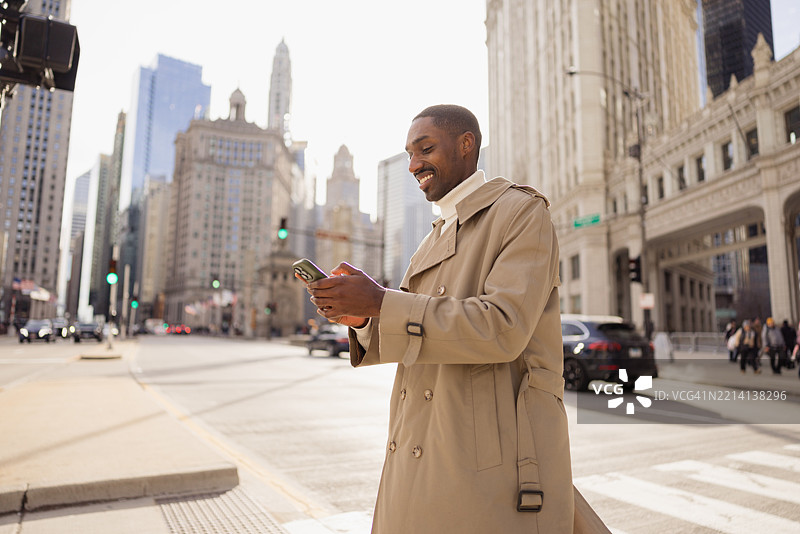 在芝加哥市中心微笑的商人使用智能手机图片素材