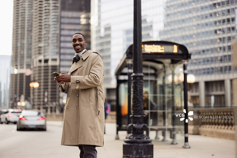 商人在芝加哥的公交车站等候时使用智能手机图片素材