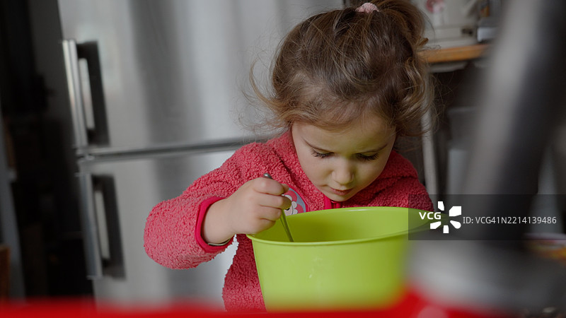 孩子与妈妈一起做蛋糕，促进儿童发展与学习。图片素材