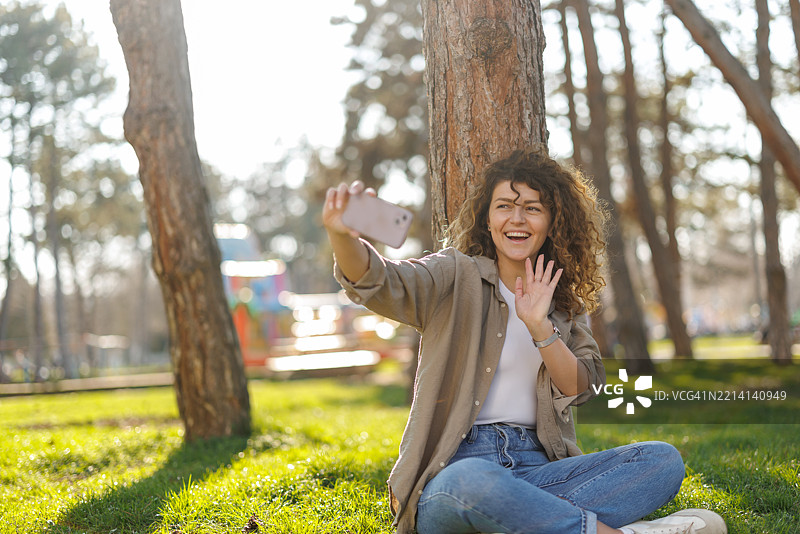 放松的女性在城市公园进行视频通话图片素材
