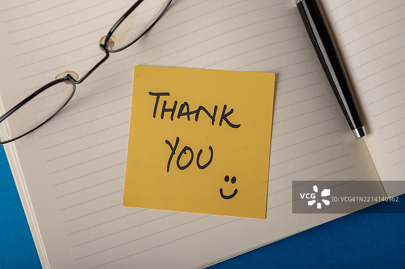 蓝色工作空间中的感谢便条本图片素材