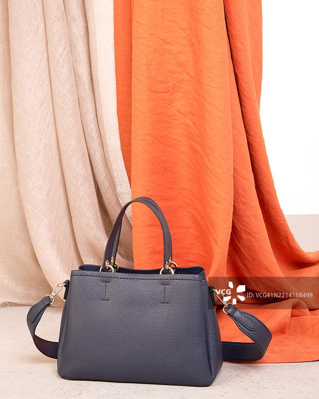 深蓝色皮革手提包，配有洗涤羊毛面料装饰图片素材