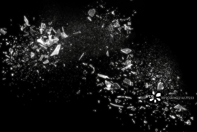 黑色背景上的破碎玻璃展示了碎玻璃的抽象纹理细节。这张图片非常适合用作背景、纹理或抽象艺术项目。图片素材