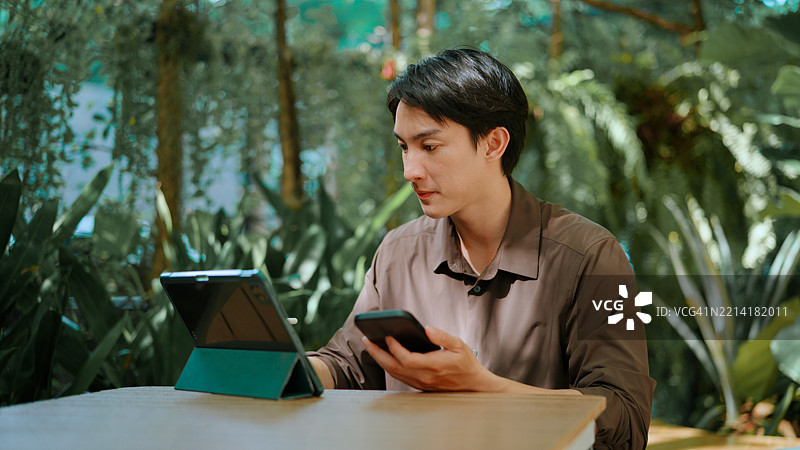 商人正在使用平板电脑和手机工作图片素材