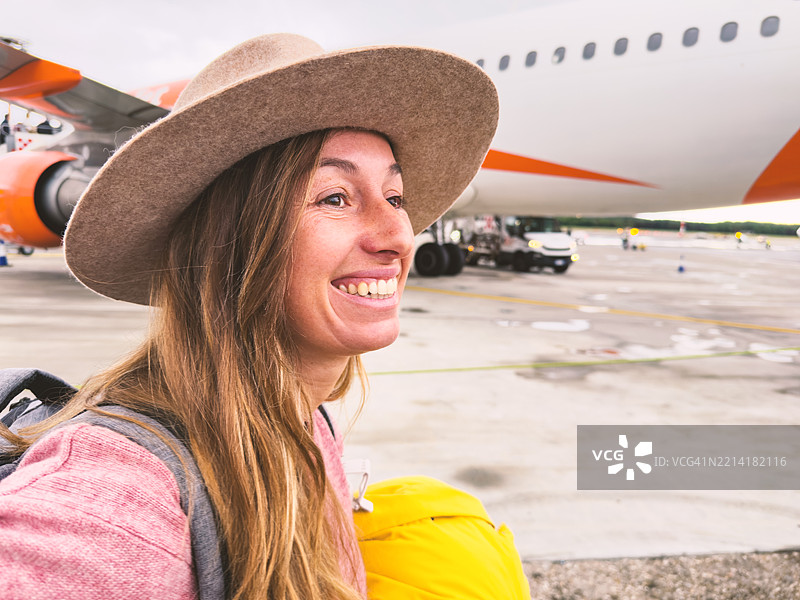 机场背景下微笑的女性与飞机相伴图片素材