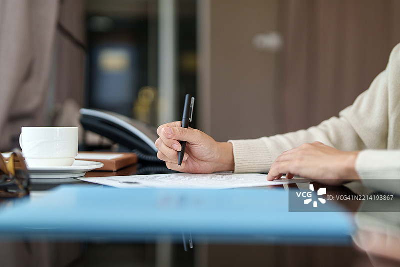 女商人在办公桌前审阅文件图片素材