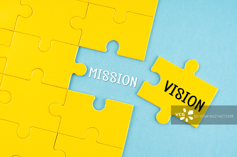 蓝色背景上的拼图块，带有“愿景”和“使命”文字，商业概念。图片素材