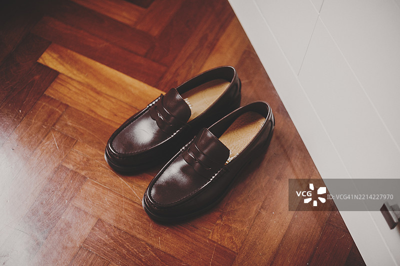 简单概念图：男性便士鞋放在木地板上图片素材