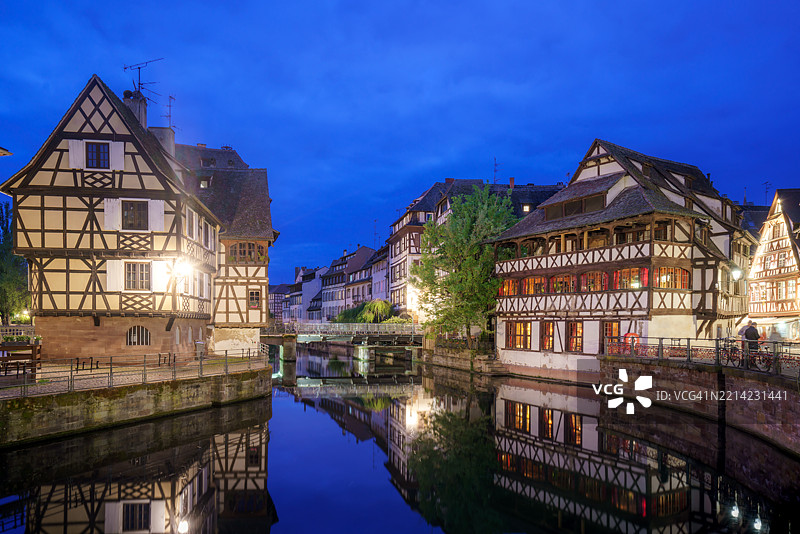 斯特拉斯堡运河旁传统半木结构房屋的迷人黄昏景色图片素材