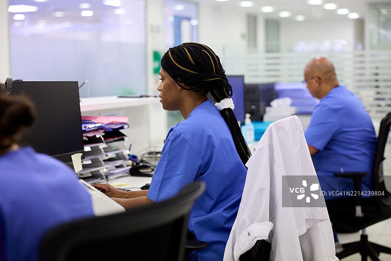 护士在医院接待处忙于电脑工作。图片素材