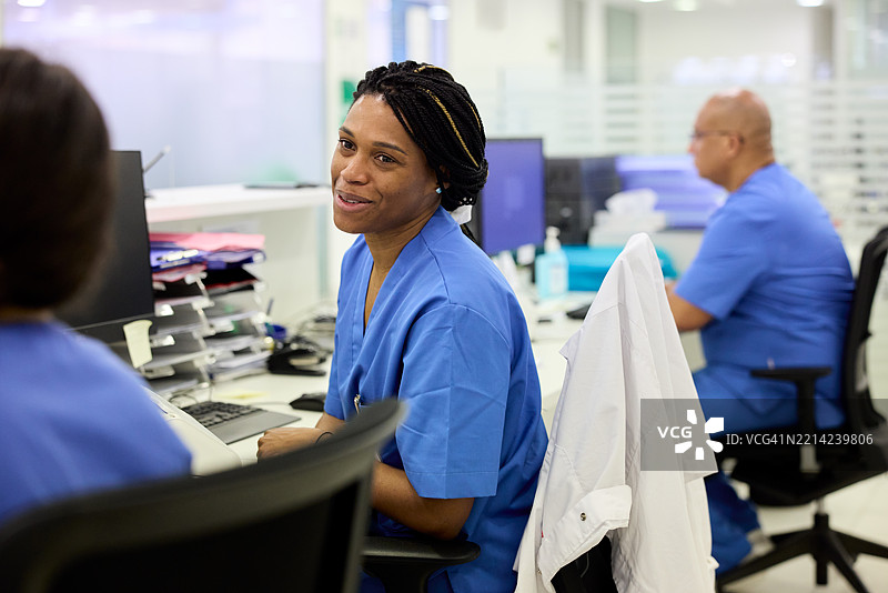 护士们在医院接待区休息时聊天。图片素材