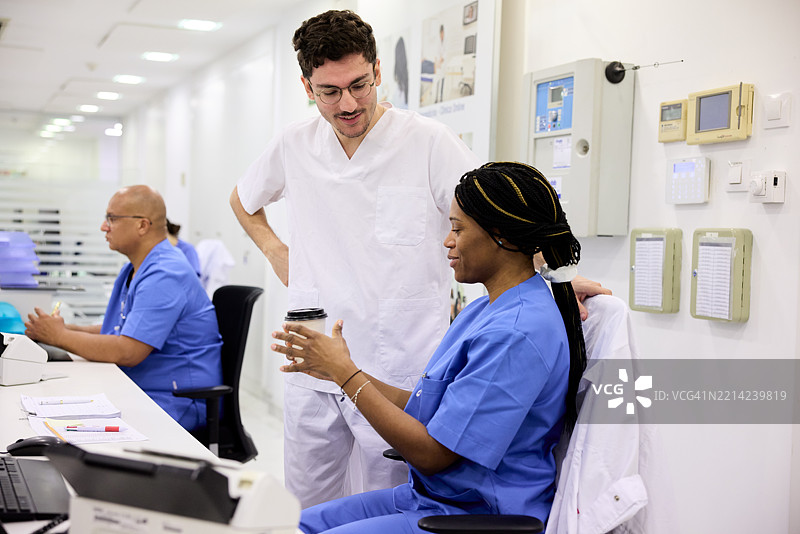 在医院接待区与同事分享咖啡。图片素材