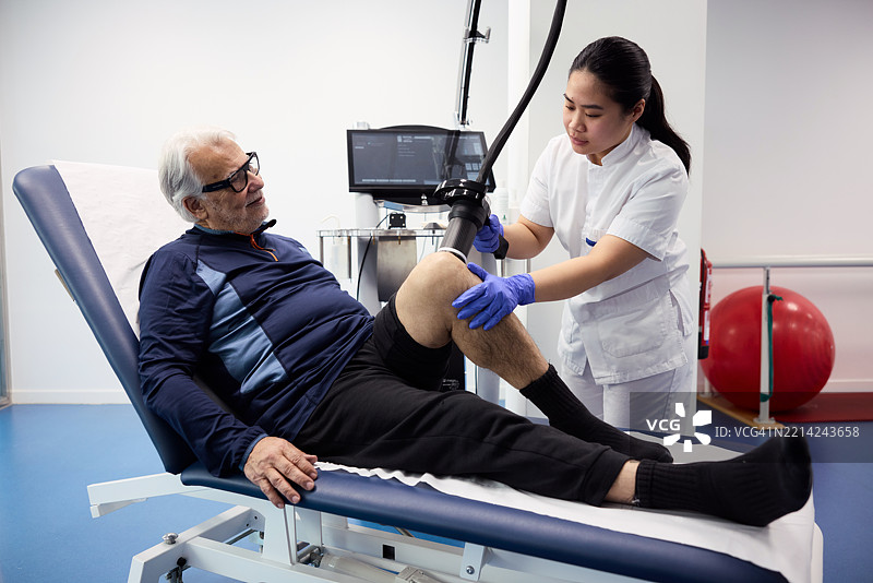 老年男性正在接受激光治疗设备的治疗图片素材