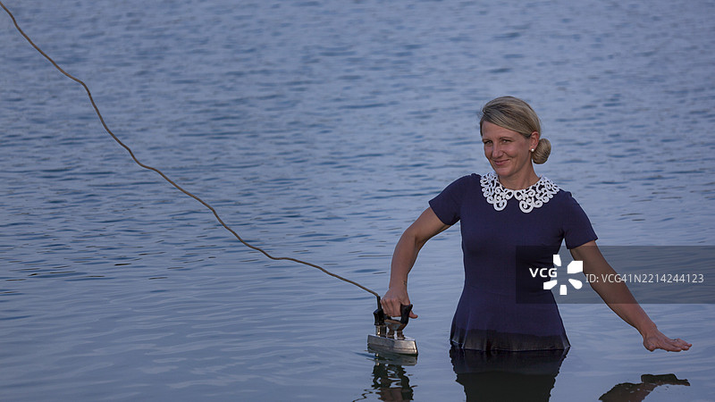 在水中用熨斗的女人，幽默而超现实的场景，象征性的图像，明德尔海姆，乌特阿尔高，巴伐利亚，德国，欧洲图片素材