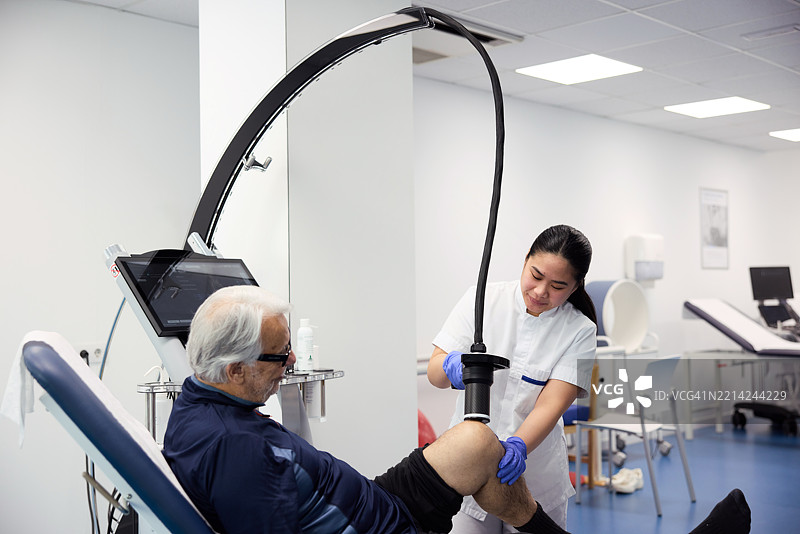 一位老年男性正在接受激光治疗。图片素材