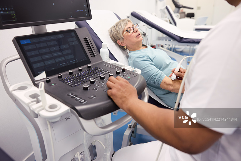 一名男士正在进行物理治疗师的超声手臂检查。图片素材