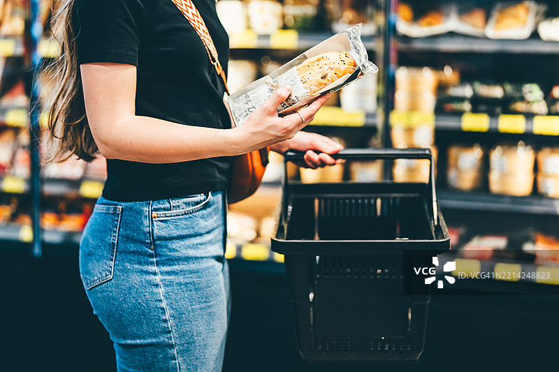 一位女性在购物中心选择零食。图片素材