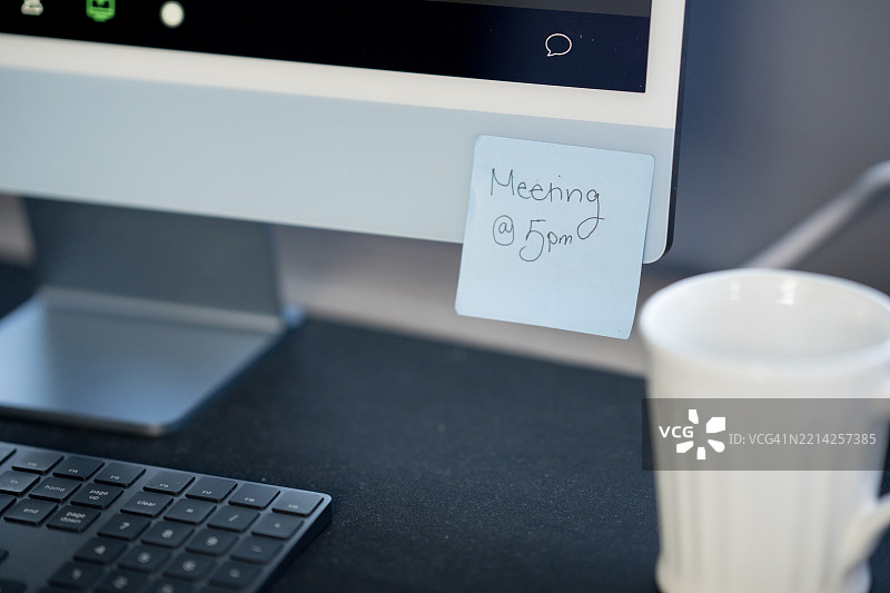 贴在电脑显示器上的会议日程提醒便条图片素材
