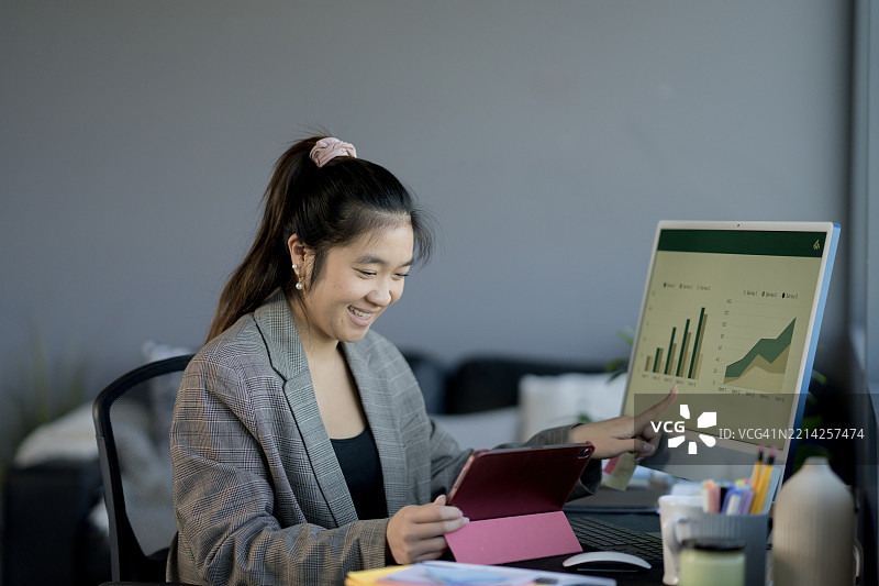 微笑的专业人士在办公室分析屏幕和平板上的增长图表图片素材