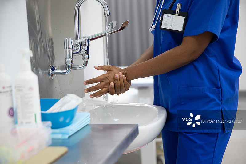 女医生用肘部触碰水龙头洗手图片素材