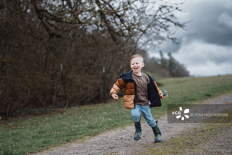 在乡间小路上奔跑的笑着的小男孩图片素材