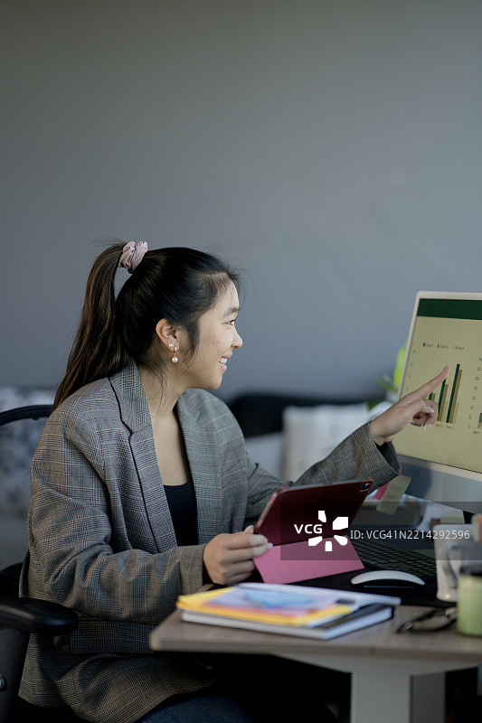 微笑的专业人士在办公室分析屏幕和平板上的增长图表图片素材