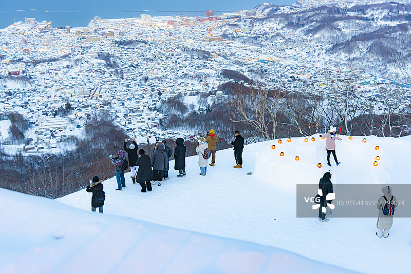 冬季傍晚，从天狗山缆车观景台俯瞰被雪覆盖的小樽市的美丽空中景观，北海道，日本图片素材