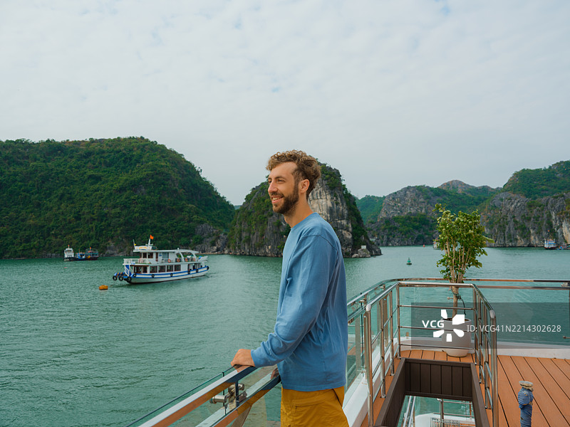 男子在游船上欣赏下龙湾的美景图片素材