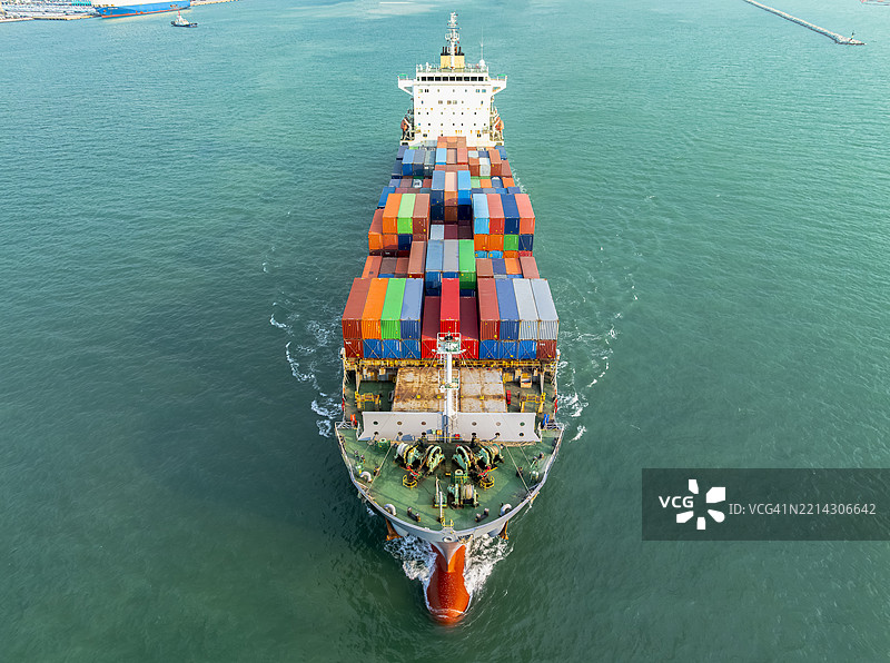 航拍视角，集装箱船正在国际港口出航。关于海运货物进出口的业务。图片素材
