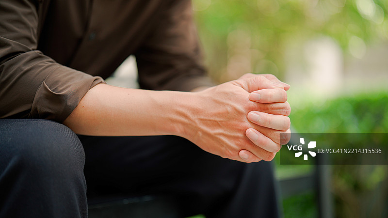 年轻的亚洲男子在公园里感到压力，经历了一天的不顺。图片素材