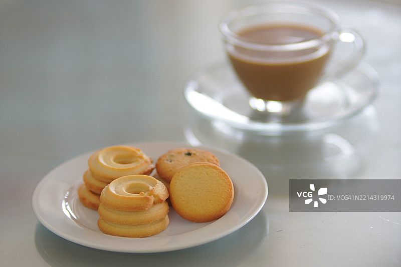 玻璃杯中的浓缩咖啡和饼干，放置在镜面桌上图片素材