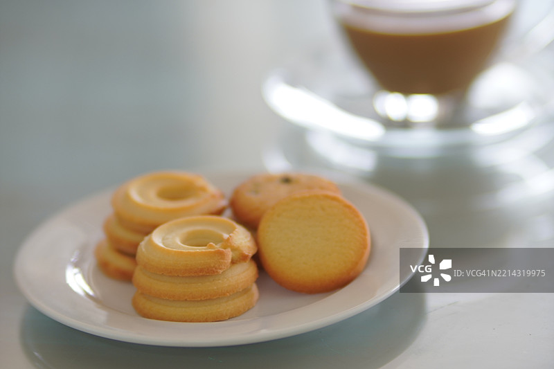 玻璃杯中的浓缩咖啡和饼干，放置在镜面桌上图片素材