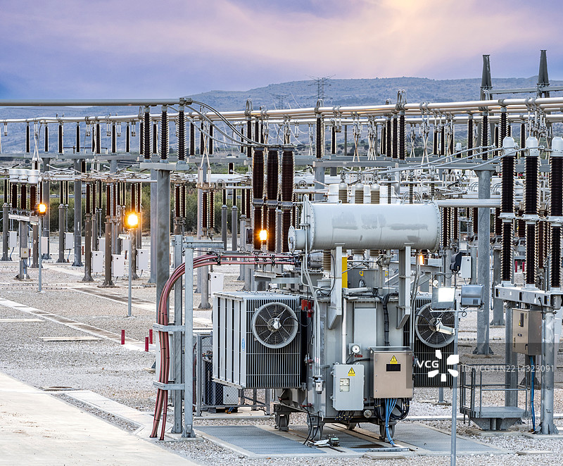 黄昏时分，灯光亮起的电力分配厂全景。图片素材