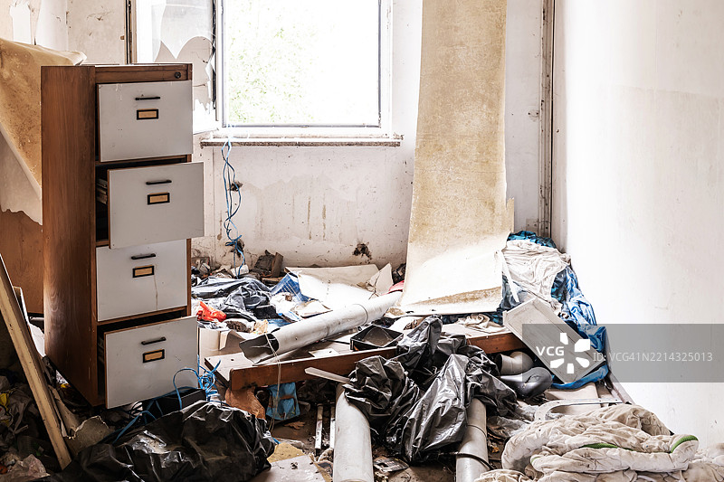 废弃建筑中一间旧杂乱办公室里的文件柜图片素材