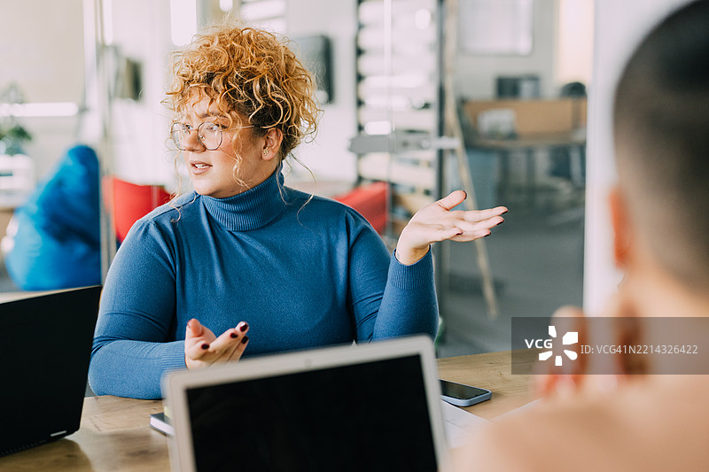 年轻女性专业人士在公司会议室讨论商业想法。图片素材